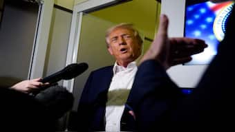 US President Donald Trump speaks to members of the media aboard Air Force One on October 24, 2025, in flight.  AFP