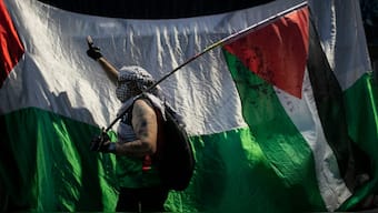 A man holds a Palestinian flag during a demonstration in solidarity with the Global Sumud Flotilla, in Rio de Janeiro. AP