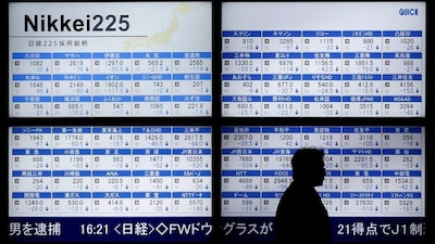 A man walks past an electronic board showing Japan's Nikkei 225 outside a brokerage in Tokyo, Japan, on January 12, 2016. (Credit: Reuters) 