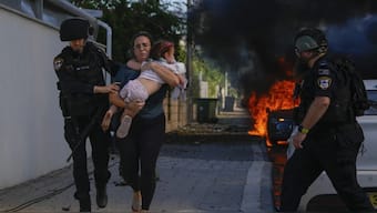 Police officers evacuate a woman and a child from a site hit by a rocket fired from the Gaza Strip, in Ashkelon, southern Israel on October 7, 2023. File image/AP