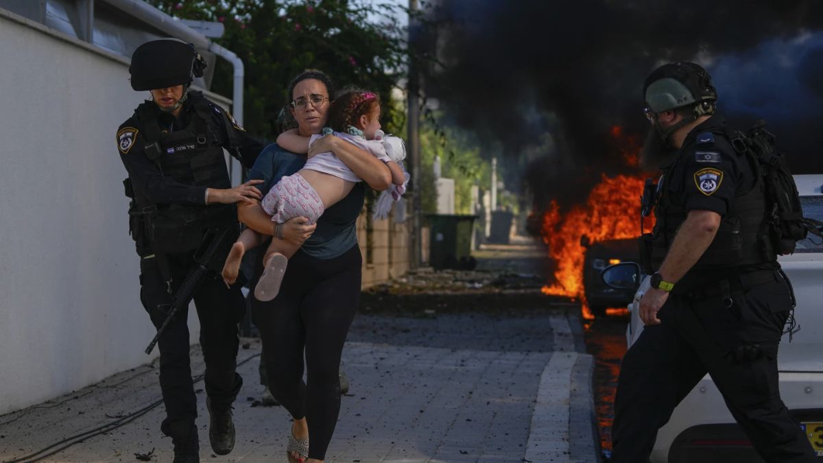 Police officers evacuate a woman and a child from a site hit by a rocket fired from the Gaza Strip, in Ashkelon, southern Israel on October 7, 2023. File image/AP Police officers evacuate a woman and a child from a site hit by a rocket fired from the Gaza Strip, in Ashkelon, southern Israel on October 7, 2023. File image/AP