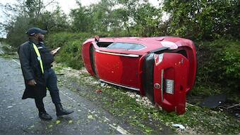 A police officer inspects a car damaged by a fallen tree after the passage of Hurricane Melissa in Manchester, Jamaica, on Wednesday. AFP