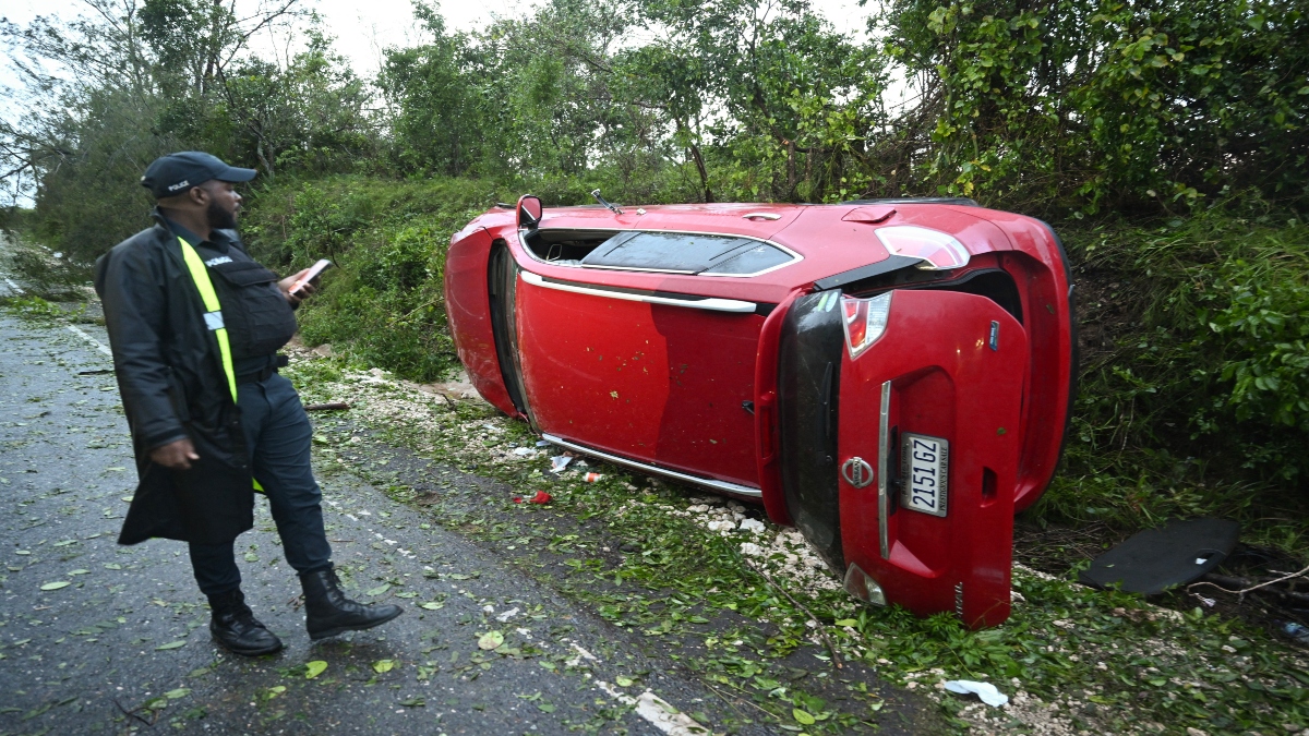 A police officer inspects a car damaged by a fallen tree after the passage of Hurricane Melissa in Manchester, Jamaica, on Wednesday. AFP A police officer inspects a car damaged by a fallen tree after the passage of Hurricane Melissa in Manchester, Jamaica, on Wednesday. AFP