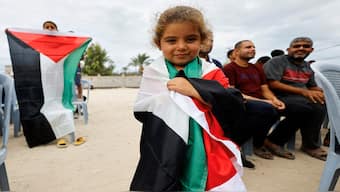 A girl holds a Palestinian flag, after US President Donald Trump announced that Israel and Hamas agreed on the first phase of a Gaza ceasefire, in the central Gaza Strip on Thursday. Reuters