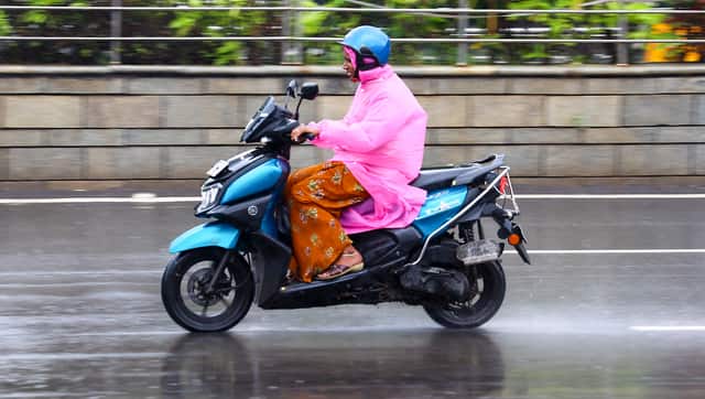A woman rides a two-wheeler amid rain owing to Cyclone 'Montha', in Chennai on Monday. PTI