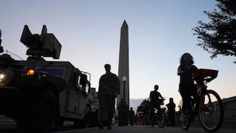 File-Tourists ride bicycles past National Guard vehicles near the Washington Monument after President Donald Trump announced a federal takeover of the Metropolitan Police Department in Washington, DC, on Tuesday. Reuters
