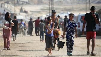Palestinians walk on a coastal path northwest of Nuseirat refugee camp as they are displaced southward following an Israeli announcement of closing Al-Rashid road towards the north of the besieged Gaza Strip on October 4, 2025.- AFP