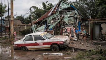 Neighbors gather around a damaged house after heavy rainfall in Poza Rica, Veracruz state, Mexico, Saturday, Oct. 11, 2025. (AP Photo)