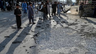 Afghan residents stand next to a damaged road in Kabul on October 16, 2025, a day after an airstrike during cross-border clashes between Afghanistan and Pakistan.- AFP