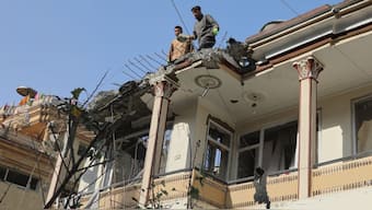 Residents stand on the roof of a damaged house as they inspect the destruction caused by Wednesday's two drone strikes, in Kabul, Afghanistan, Thursday, Oct. 16, 2025. (AP Photo/Siddiqullah Alizai)
