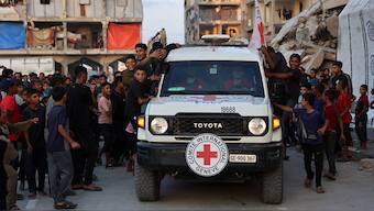 Palestinian children cheer as members of the International Committee of the Red Cross (ICRC) arrive at a site where people are digging with excavators, reportedly in search for bodies in Khan Yunis in the southern Gaza Strip, on October 17, 2025.- AP