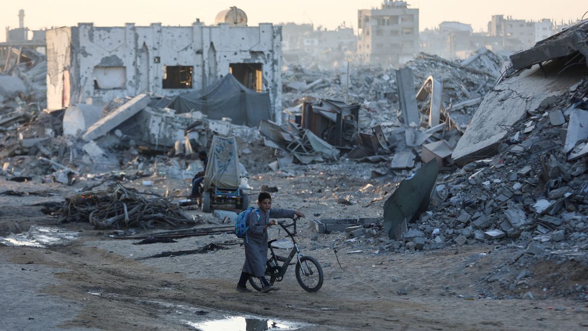 A Palestinian boy pushes his bicycle past the ruins of destroyed buildings in the Sheikh Radwan neighborhood of Gaza City on October 22, 2025.- AFP A Palestinian boy pushes his bicycle past the ruins of destroyed buildings in the Sheikh Radwan neighborhood of Gaza City on October 22, 2025.- AFP