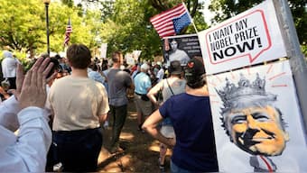 Activists carry signs during a protest against President Donald Trump's federal takeover of policing of the District of Columbia, August 16, 2025, in Washington, DC, US. File Image/AP