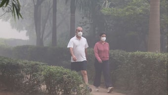 People walk wearing face masks at a park amidst smog on the day after Diwali, the festival of lights, in New Delhi, October 21, 2025. Reuters