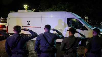Israeli policemen salute as vehicles carrying bodies of four deceased hostages, who had been held in Gaza since the deadly October 7, 2023 attack, arrive at forensic institute after being released amid a ceasefire between Israel and Hamas, in Tel Aviv, Israel. Reuters