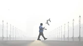 A pedestrian walks amid smog, near India Gate in New Delhi on October 29, a day after cloud seeding trials took place. Unfortunately, it didn't induce rain, leaving Delhiites dismayed. AFP