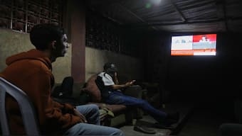 Palestinians follow the news on a television after the announcement that Israel and Hamas have agreed to the first phase of a peace plan to pause fighting, in the central Gaza Strip. AP