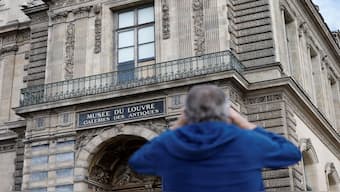 A man takes a picture of a broken window protected by a wooden panel at the Louvre Museum as the museum remains closed after a spectacular jewel heist by thieves who broke into the landmark by using a crane and smashing an upstairs window, stealing priceless jewelry from an area that houses the French crown jewels before escaping on motorbikes, in Paris, France. Reuters