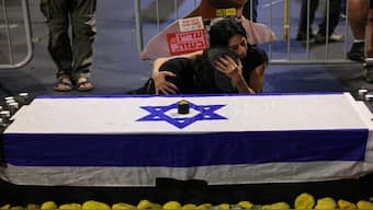 Einav Zangauker (R), mother of kidnapped Israeli Matan Zangauker, comforts a friend by a fake coffin during an anti-government protest calling for action to secure the release of the hostage in Tel Aviv in August. Now, the delay in returning the bodies of the deceased hostages puts the Gaza peace plan at risk. File image/AFP