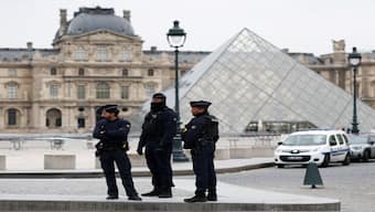 Police stand near the pyramid of the Louvre museum on Sunday. Reuters