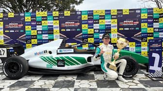 Itsuki Sato poses with the winner's trophy in front of his race car. Image: Vishal Tiwari/FP