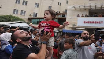 Palestinians celebrate outside Deir al-Balah's Shuhada al-Aqsa hospital in the central Gaza Strip, following news of a new Gaza ceasefire deal. AFP