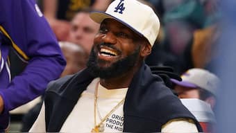 LeBron James smiles while watching a game. Image: Reuters