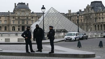 French police officers stand in front of the Louvre Museum after robbery, in Paris on October 19. Robbers broke in to the Louvre and fled with jewellery. AFP