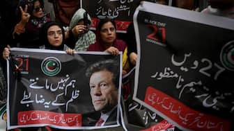 Pakistan Tehreek-e-Insaf (PTI) party supporters carry a poster of their leader and former Prime Minister Imran Khan, during a protest against the 27th constitutional amendment, in Karachi on November 21, 2025. File Photo/AFP
