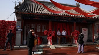 Newlywed couples pose for pictures at the Huguo Guanyin Temple, an outdoor marriage registration site in Beijing, China, October 28, 2025. Reuters 
