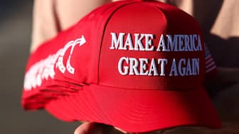 A member of Turning Point USA distributes Maga hats. File image/AFP