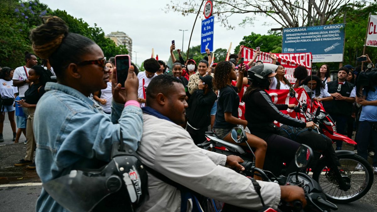 Residents take part in a protest at the Penha Complex in Rio de Janeiro, Brazil, on October 31, 2025, to demand justice for victims of a massive police raid that left at least 117 suspected criminals and four police officers dead. (Photo by Pablo PORCIUNCULA / AFP) Residents take part in a protest at the Penha Complex in Rio de Janeiro, Brazil, on October 31, 2025, to demand justice for victims of a massive police raid that left at least 117 suspected criminals and four police officers dead. (Photo by Pablo PORCIUNCULA / AFP)