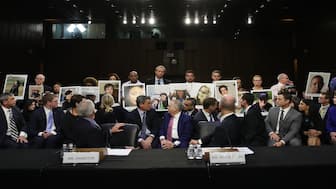 Family members of those who died aboard Ethiopian Airlines Flight 302 hold photographs of their loved ones as Dennis Muilenburg (R), President and CEO of the Boeing Company, and John Hamilton (L), Vice President and Chief Engineer of Boeing Commercial Airplanes, testify before the Senate Commerce Committee October 29, 2019 in Washington, DC. AFP