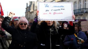 A protester carries a sign that reads "the masculine does not take over the feminine" during the International Day for the Elimination of Violence Against Women in Bordeaux, south-western France, on November 22, 2025. AFP