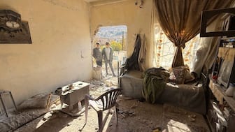 Two youth inspect the site of an Israeli militray operation in the southern Syrian village of Beit Jin on November 28, 2025. AFP
