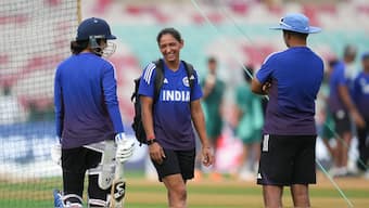 India captain Harmanpreet Kaur chats with senior opener Smriti Mandhana and head coach Amol Muzumdar during a practice session on the eve of the ICC Women's World Cup final against South Africa in Navi Mumbai. PTI
