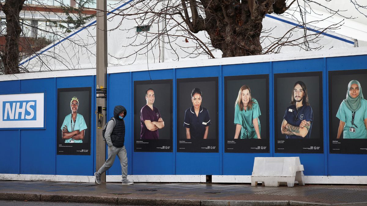A person walks past images of National Health Service (NHS) workers displayed on hoardings outside a temporary field hospital at St George's Hospital in London, UK, January 8, 2022. File Image/Reuters A person walks past images of National Health Service (NHS) workers displayed on hoardings outside a temporary field hospital at St George's Hospital in London, UK, January 8, 2022. File Image/Reuters