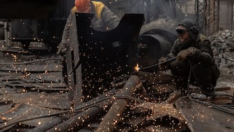 Employees work next to scorched equipment at a power plant of Ukrainian energy provider DTEK, which was damaged by constant Russian air attacks, at an undisclosed location on November 13, 2025, amid the Russian invasion of Ukraine.- AFP