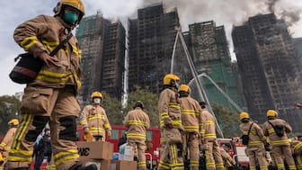 Firemen get ready after a major fire swept through several apartment blocks at the Wang Fuk Court residential estate in Hong Kong's Tai Po district on November 27, 2025. Image- AFP