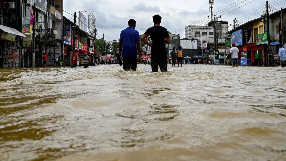 Residents wade through a flooded street after heavy rainfall. Image Credit: AFP Residents wade through a flooded street after heavy rainfall. Image Credit: AFP