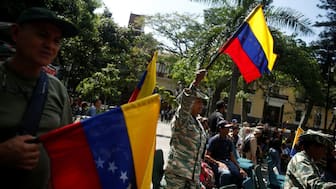 Members of the National Militia hold Venezuelan flags as they attend a military drill following Venezuelan President Nicolas Maduro's call to defend national sovereignty, amid rising tensions with the US, in Caracas, Venezuela, October 4, 2025. File Image/Reuters