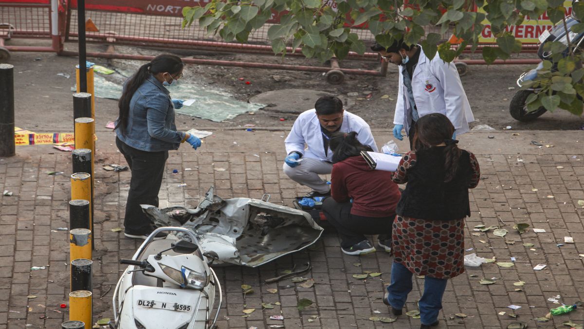 Forensic officials collect samples from the site in the aftermath of the blast that occurred near Red Fort Metro Station on Monday, killing at least nine people and gutting several vehicles, in New Delhi. PTI Forensic officials collect samples from the site in the aftermath of the blast that occurred near Red Fort Metro Station on Monday, killing at least nine people and gutting several vehicles, in New Delhi. PTI