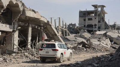 An International Committee of the Red Cross (ICRC) vehicle passes a destroyed building in Gaza City on November 2, 2025, as efforts resume to recover the bodies of slain Israeli hostages. (AFP)