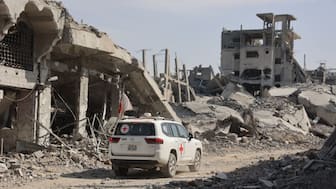 An International Committee of the Red Cross (ICRC) vehicle passes a destroyed building in Gaza City on November 2, 2025, as efforts resume to recover the bodies of slain Israeli hostages. (AFP)