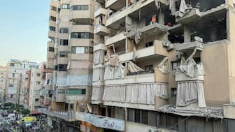 Workers remove debris from a residential building in Beirut’s southern Haret Hreik neighbourhood following an Israeli air strike on November 23, 2025. (AFP)