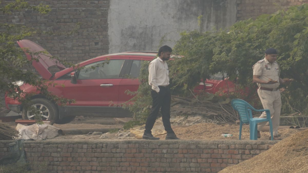 Officials at the site after a red Ford EcoSport car suspected to be linked to the Delhi Red Fort blast case has been traced and seized in Faridabad district's Khandawali. PTI Officials at the site after a red Ford EcoSport car suspected to be linked to the Delhi Red Fort blast case has been traced and seized in Faridabad district's Khandawali. PTI