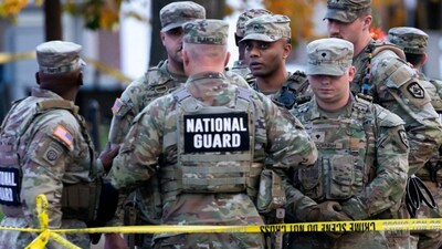 National Guard members stand together behind yellow tape, after two soldiers were shot near the White House in Washington, DC, , November 26. Reuters