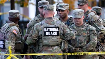 National Guard members stand together behind yellow tape, after two soldiers were shot near the White House in Washington, DC, , November 26. Reuters