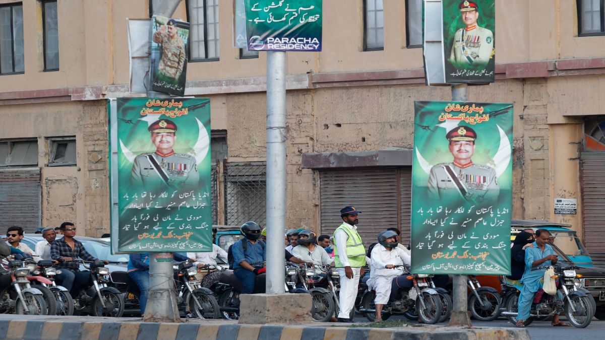 A police officer stands in front of the traffic, next to posters of the Chief of Army Staff of Pakistan Asim Munir, in Karachi. File image/Reuters A police officer stands in front of the traffic, next to posters of the Chief of Army Staff of Pakistan Asim Munir, in Karachi. File image/Reuters
