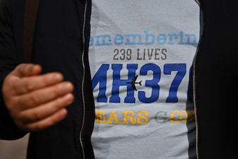 Jiang Hui, a relative of a passenger on board the missing Malaysia Airlines flight MH370, is seen wearing a shirt commemorating the ill-fated flight as he talks to media in Beijing on March 8, 2025, on the 11th anniversary of the flights disappearance. (Photo by Pedro Pardo / AFP)